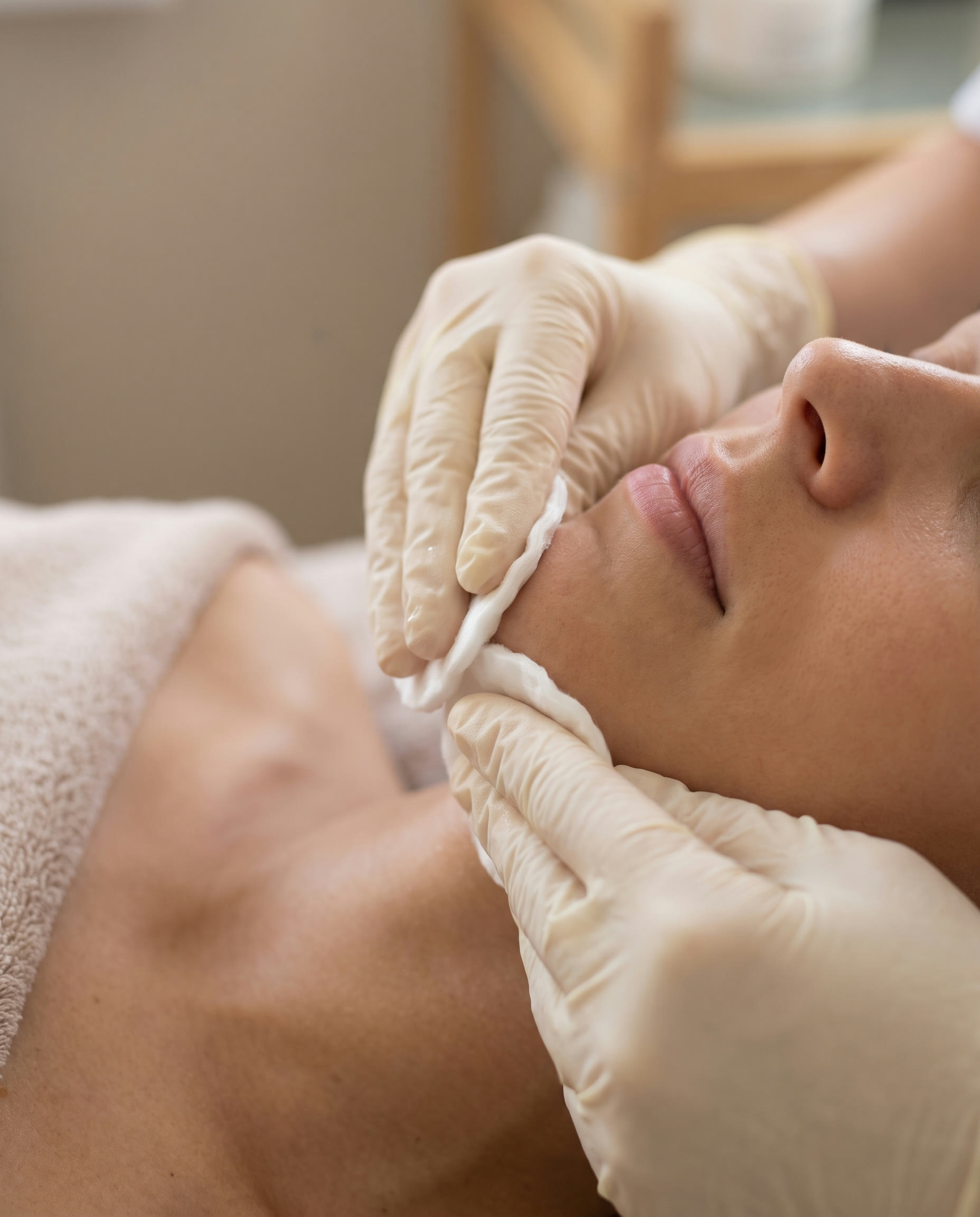 Trattamento viso in primo piano, gesto di cura sulla pelle